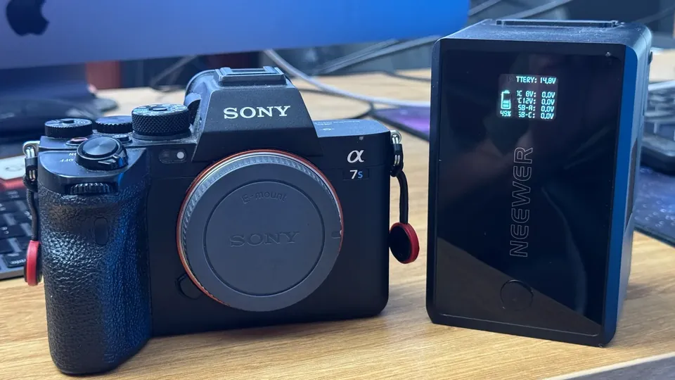 Sony α7S-series camera beside a NEEWER V-Mount battery