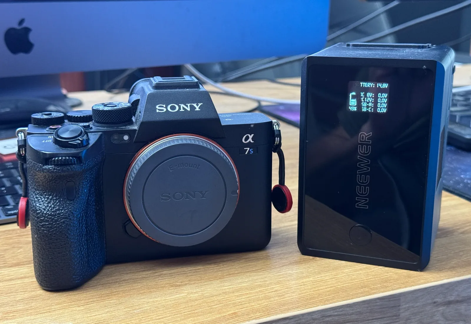 Sony α7S-series camera beside a NEEWER V-Mount battery