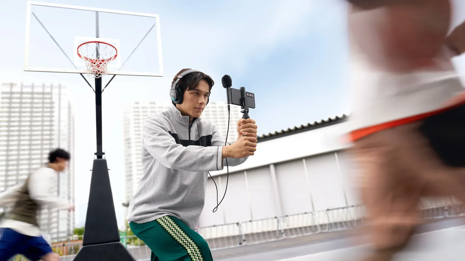 Persona grabando con un móvil y el micrófono Sony ECM-AX10 en una pista de baloncesto