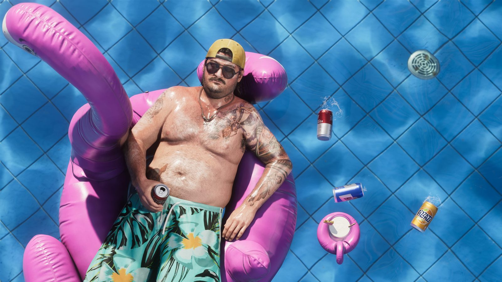 Cal Hampton tumbado en un flotador de flamenco rosa en una piscina, con gorra hacia atrás, gafas de sol y una lata en la mano