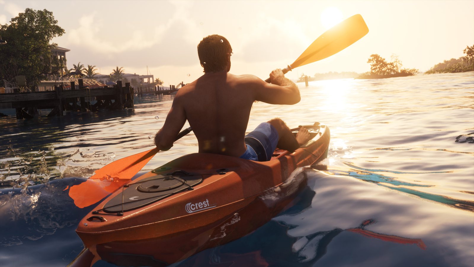 Jason rema en un kayak naranja al atardecer entre muelles y casas de la costa de Leonida