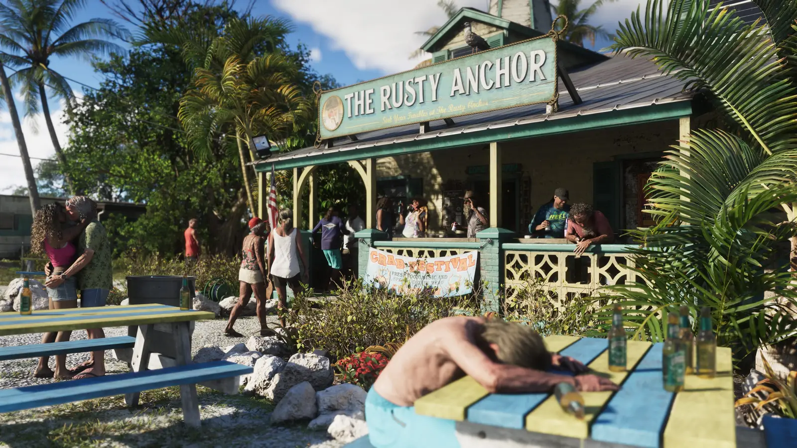 Customers on the patio of The Rusty Anchor bar in Leonida Keys, with a man asleep on a picnic table