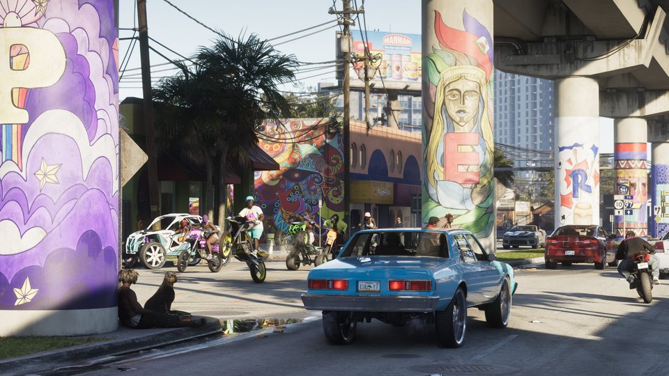 A Vice City street filled with murals, cars, bikes, pedestrians and signs in GTA 6