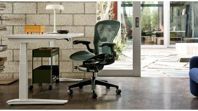 Mesh Herman Miller Aeron chair beside a desk